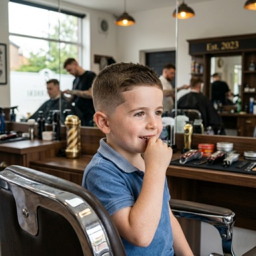 Short fade kids haircut for boys with clean faded sides and short textured hair on top