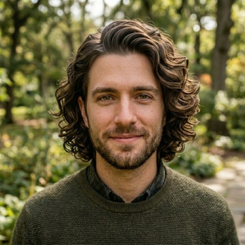 Wavy side part medium hairstyle for men with natural texture and clean structure