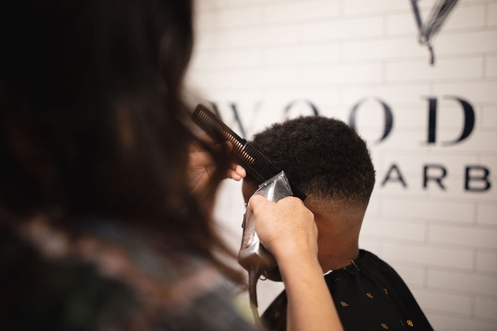 A Woodward barber carefully shaping a haircut